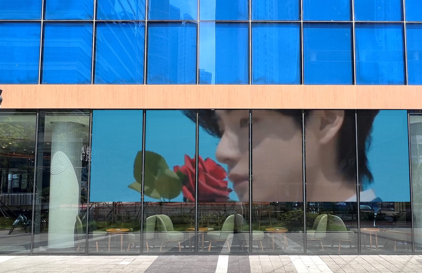 A real advertising creative displayed on a smart-film glass storefront